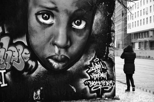 Portugal, Lisbon, woman walking by a mural painting on a wall downtown